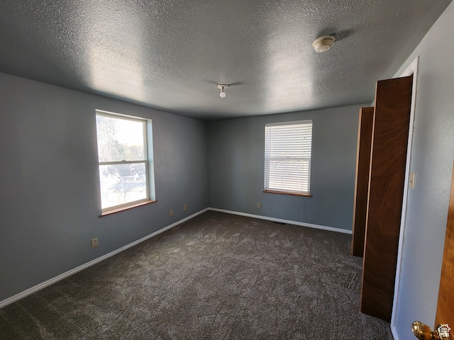 carpeted spare room with a textured ceiling