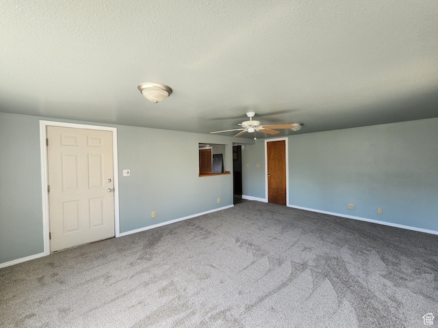 unfurnished room with ceiling fan, carpet flooring, and a textured ceiling