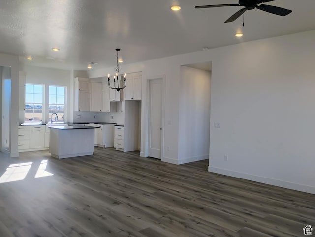 2390 W 5190 N Unit 4, Cedar City, UT 84721 - kitchen with hanging light fixtures, dark hardwood / wood-style floors, white cabinets, a kitchen island, and ceiling fan with notable chandelier