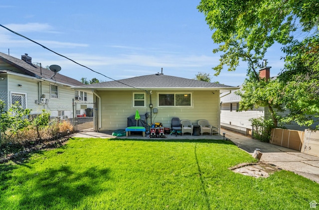 rear view of property featuring a patio and a lawn