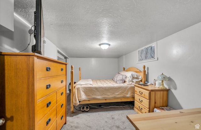 bedroom with carpet floors and a textured ceiling