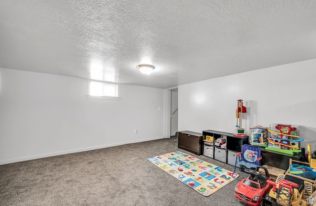 rec room featuring carpet and a textured ceiling