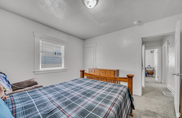 bedroom featuring a textured ceiling and carpet flooring