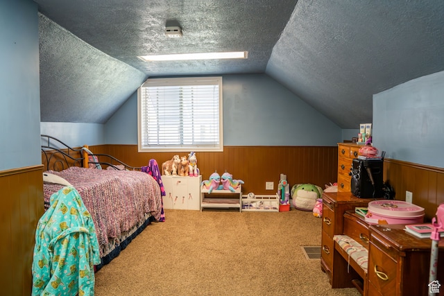 carpeted bedroom featuring a textured ceiling, wainscoting, and wood walls