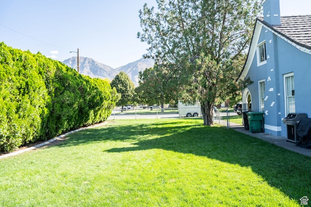 view of yard with fence, a gate, and a mountain view