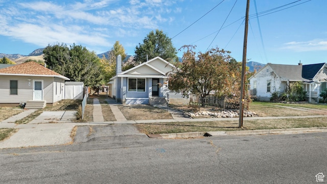 bungalow with fence, driveway, entry steps, and a mountain view