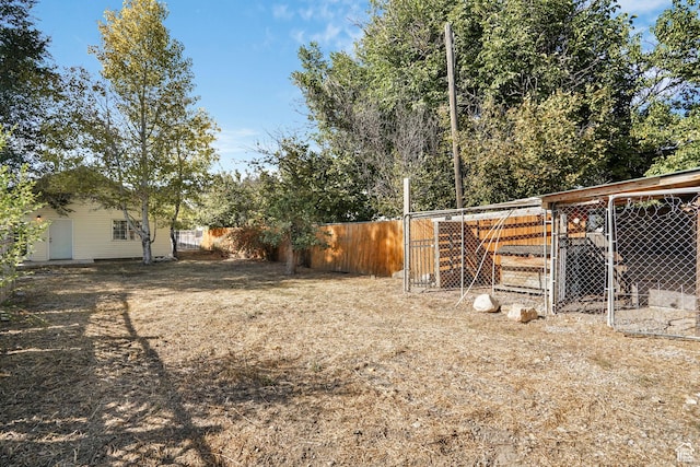 view of yard with an outbuilding, fence, and exterior structure