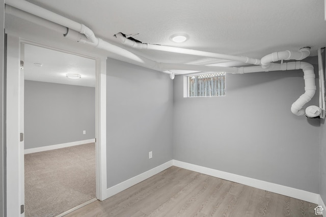 below grade area featuring light wood-style floors and baseboards