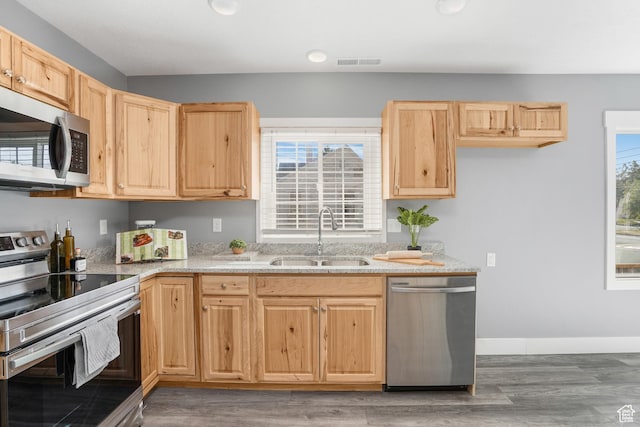 kitchen with light brown cabinets, visible vents, a sink, and appliances with stainless steel finishes
