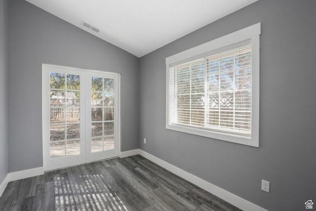 unfurnished room with visible vents, vaulted ceiling, baseboards, and dark wood-style floors
