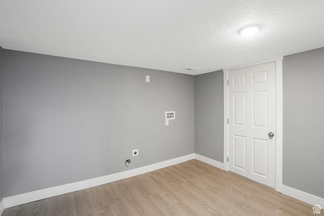 interior space featuring light wood-style flooring, a textured ceiling, baseboards, and visible vents