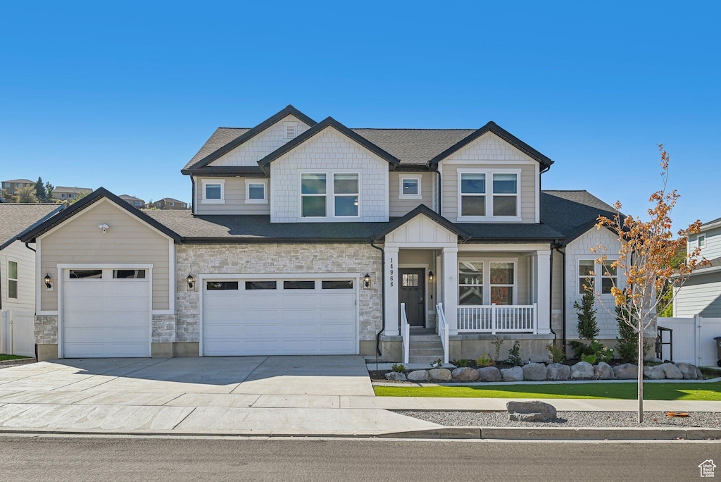 14968 S Springtime Rd, Draper, UT 84020 - craftsman house with a porch, driveway, roof with shingles, and stone siding