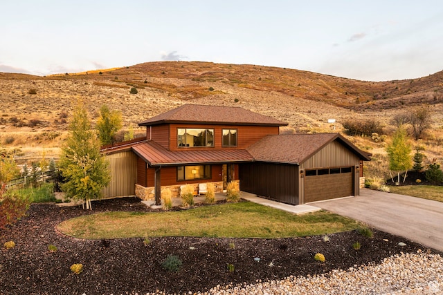 view of front facade with a mountain view, a front lawn, and a garage
