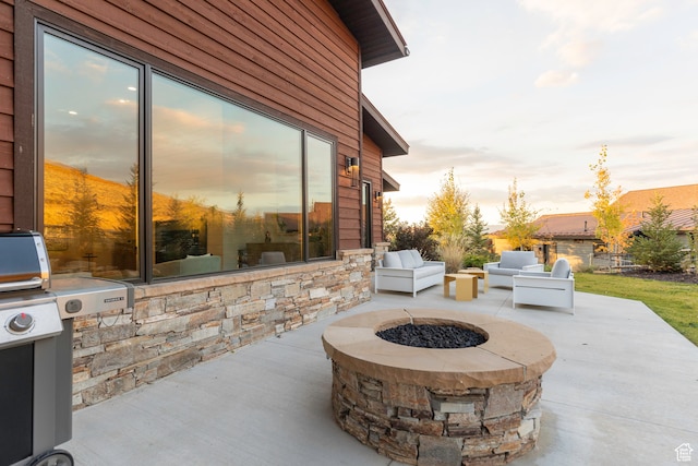 patio terrace at dusk with area for grilling and a fire pit