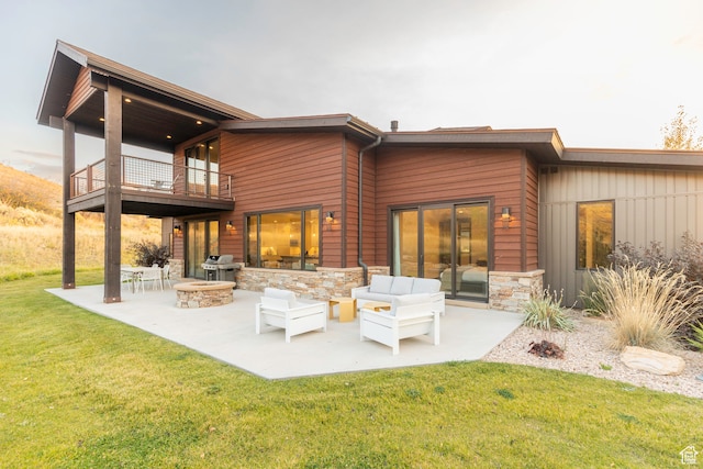 rear view of house featuring a yard, a patio area, a balcony, and an outdoor hangout area