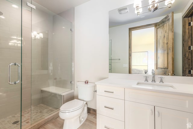 bathroom with vanity, toilet, and a shower with shower door