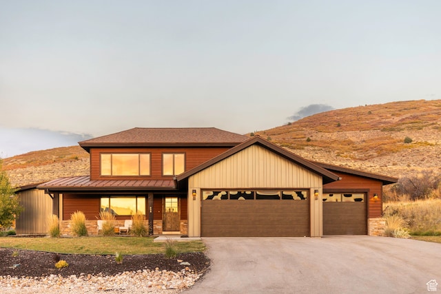 view of front of home featuring a mountain view, a porch, and a garage