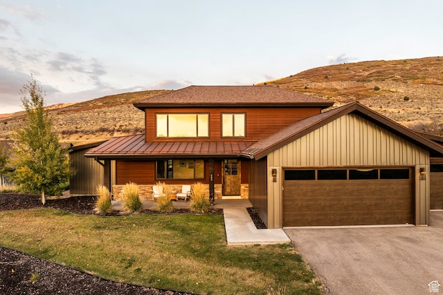 view of front of home featuring a garage, a mountain view, and a lawn