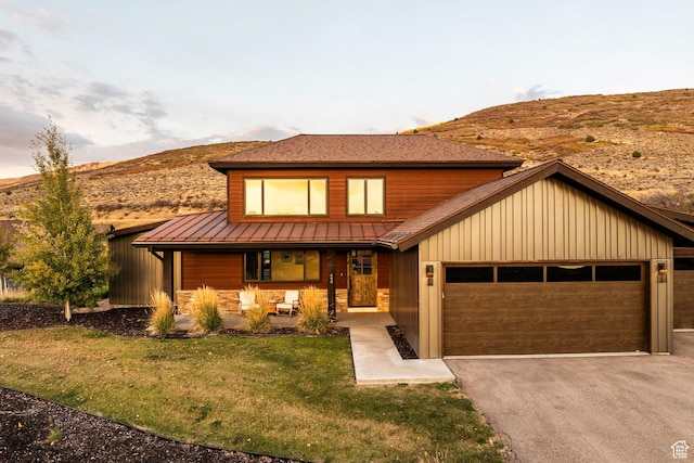 498 Thorn Creek Dr, Kamas, UT 84036 - view of front facade featuring a porch, an attached garage, asphalt driveway, a standing seam roof, and a mountain view