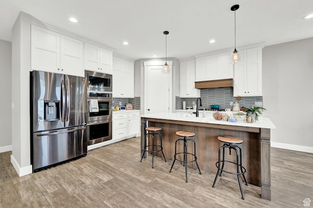 170 E 3900 N, North Ogden, UT 84414 - kitchen featuring stainless steel appliances, baseboards, light countertops, light wood-type flooring, and recessed lighting