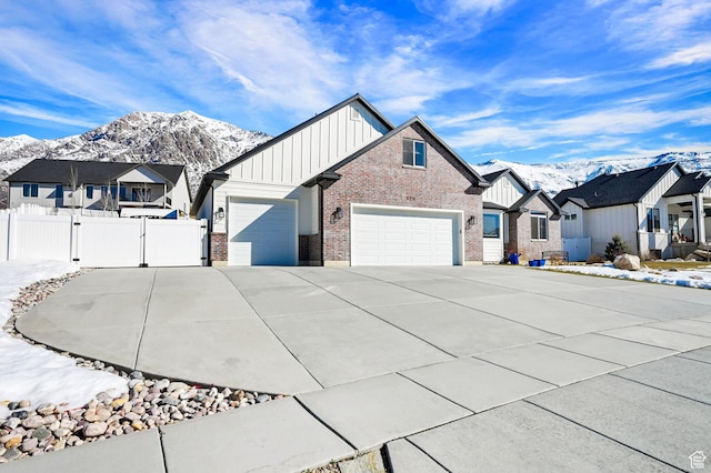 170 E 3900 N, North Ogden, UT 84414 - view of front of house featuring board and batten siding, a mountain view, brick siding, and a garage