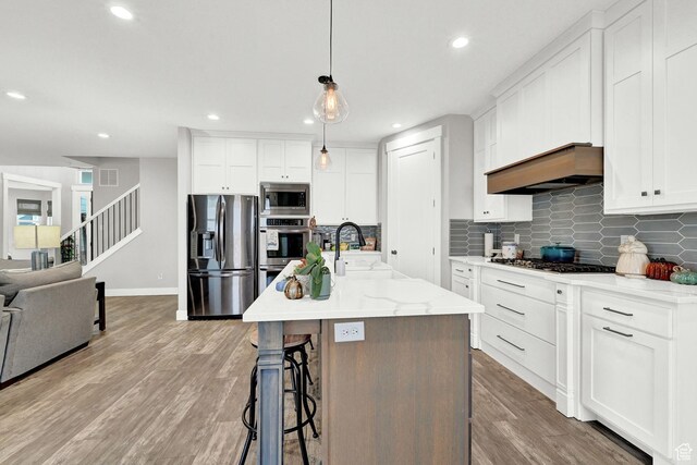 170 E 3900 N, North Ogden, UT 84414 - kitchen with stainless steel appliances, wood finished floors, white cabinets, tasteful backsplash, and recessed lighting