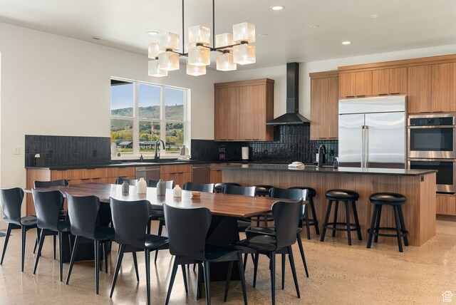 70 W 350 S, Garden City, UT 84028 - kitchen with tasteful backsplash, appliances with stainless steel finishes, sink, hanging light fixtures, and wall chimney exhaust hood