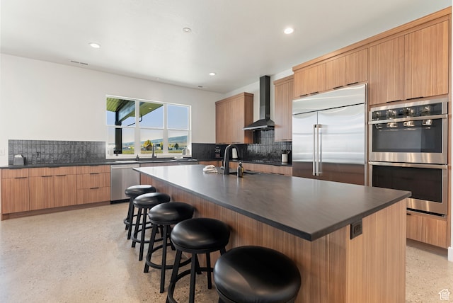 70 W 350 S, Garden City, UT 84028 - kitchen featuring decorative backsplash, wall chimney range hood, a kitchen breakfast bar, an island with sink, and appliances with stainless steel finishes