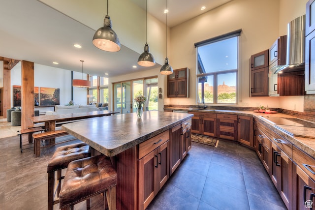 425 Amber Ln, Castle Valley, UT 84532 - kitchen with sink, a kitchen island, dark tile patterned floors, a kitchen breakfast bar, and decorative light fixtures