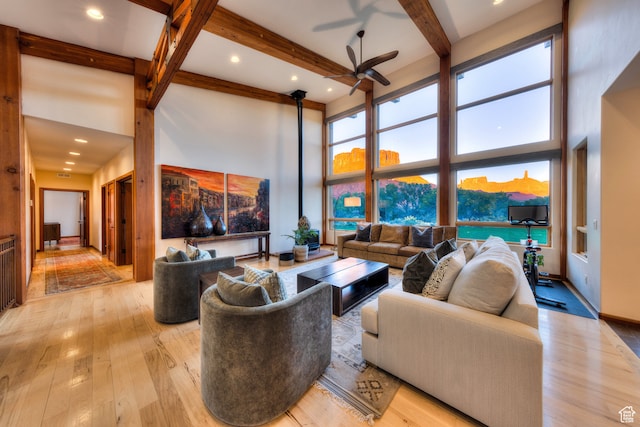 425 Amber Ln, Castle Valley, UT 84532 - living room with light hardwood / wood-style floors, beamed ceiling, a high ceiling, and ceiling fan