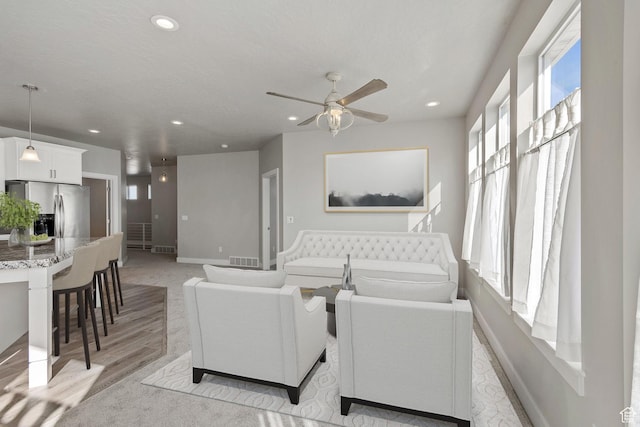 living area with ceiling fan, baseboards, and recessed lighting