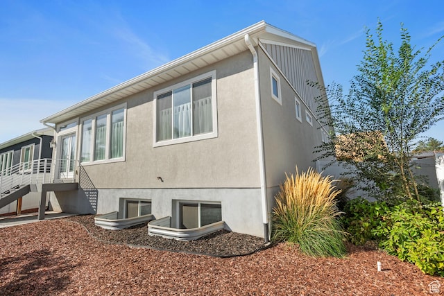 view of property exterior with a sunroom and stairs