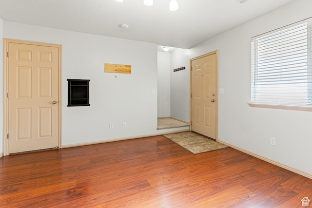 unfurnished room featuring baseboards and wood finished floors