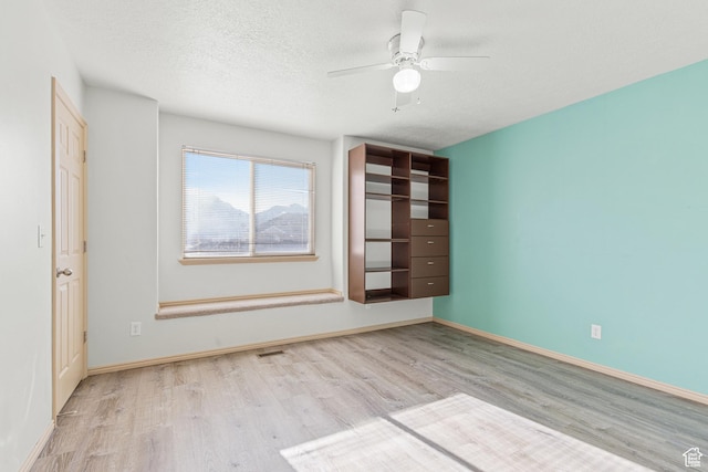unfurnished bedroom with baseboards, visible vents, wood finished floors, and a textured ceiling