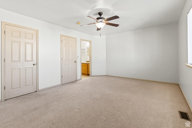 unfurnished bedroom featuring light carpet, connected bathroom, baseboards, and visible vents