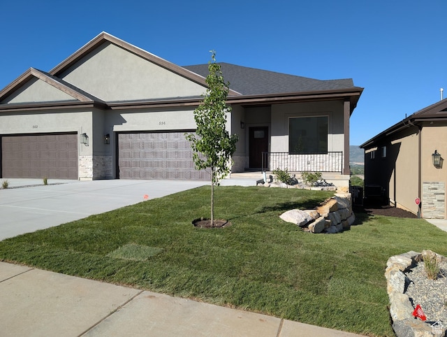 556 N Olympic Way Unit 38, Midway, UT 84049 - view of front facade with stucco siding, an attached garage, a front yard, driveway, and a porch