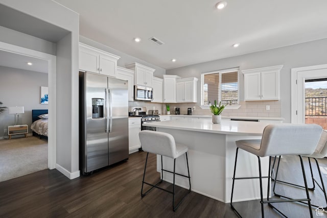 974 N Pleasant Valley Ln, Washington, UT 84780 - kitchen featuring stainless steel appliances, visible vents, a kitchen bar, and white cabinetry