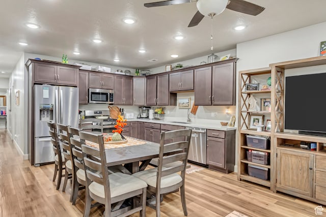 1441 E Snowflake Ave N, Eagle Mountain, UT 84005 - kitchen with sink, appliances with stainless steel finishes, dark brown cabinetry, and light hardwood / wood-style floors