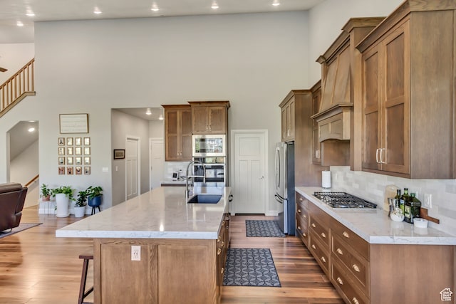 1441 E Snowflake Ave N, Eagle Mountain, UT 84005 - kitchen featuring hardwood / wood-style floors, sink, a kitchen island with sink, and stainless steel appliances
