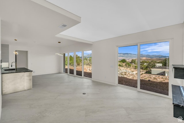 734 S 1220 W, Hurricane, UT 84737 - unfurnished living room featuring a sink, baseboards, and a mountain view