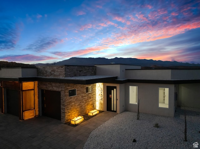 734 S 1220 W, Hurricane, UT 84737 - exterior space with an attached garage, stone siding, stucco siding, a mountain view, and decorative driveway
