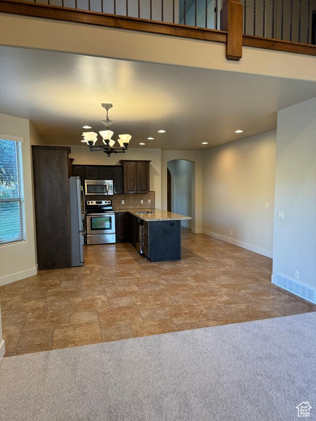1260 N 200 W, Bountiful, UT 84010 - kitchen featuring a sink, arched walkways, a chandelier, stainless steel appliances, and baseboards