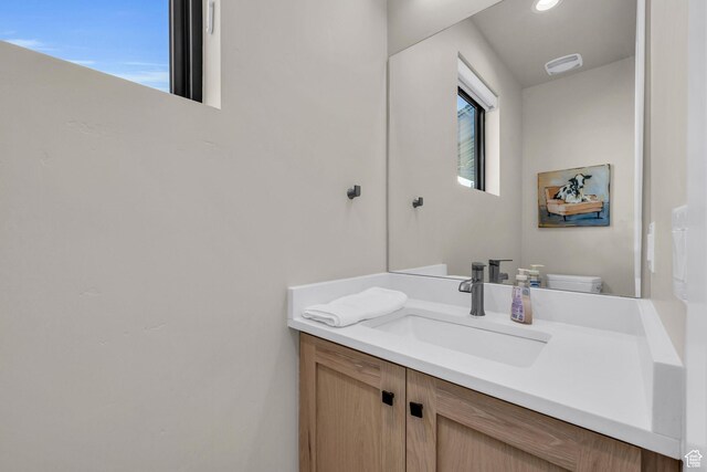 half bathroom with toilet and vanity