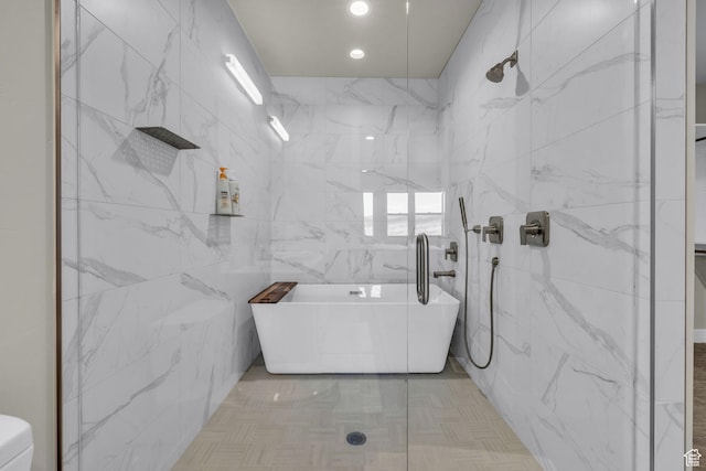 full bath with walk in shower, a freestanding bath, and tile walls