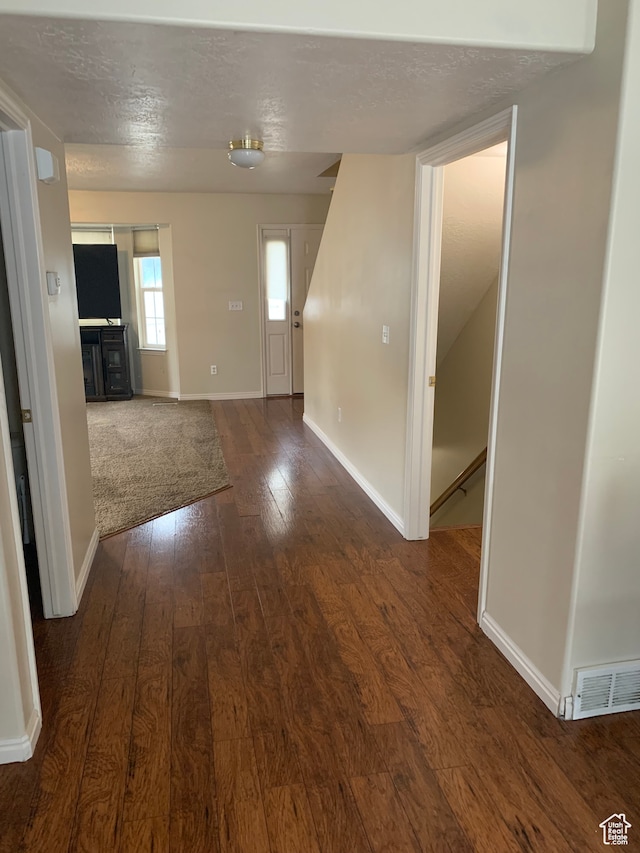 unfurnished room featuring dark hardwood / wood-style floors and a textured ceiling