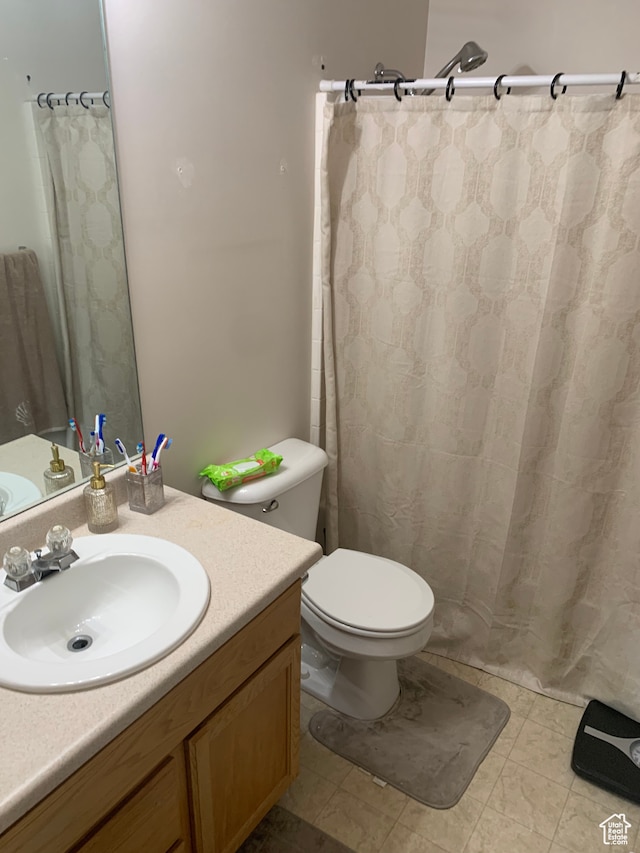 bathroom with vanity, curtained shower, toilet, and tile patterned floors