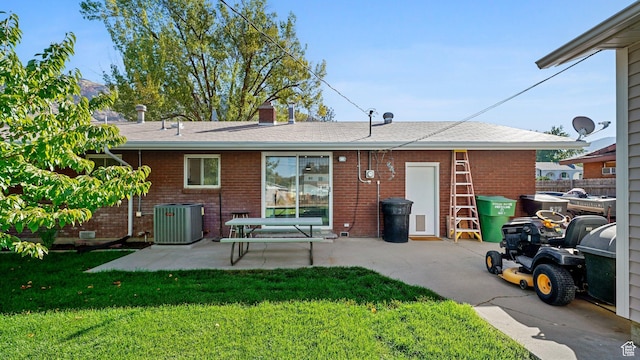 535 N 300 E, Brigham City, UT 84302 - back of house with central air condition unit, a patio, a lawn, and brick siding