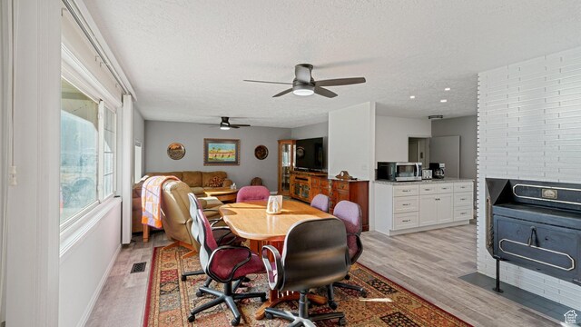 535 N 300 E, Brigham City, UT 84302 - dining area with light wood-style floors, baseboards, a ceiling fan, and a textured ceiling