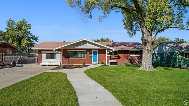 535 N 300 E, Brigham City, UT 84302 - view of front of house with brick siding, a front lawn, and fence