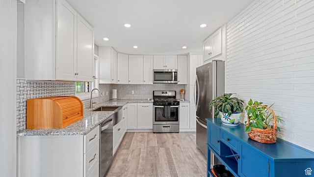 535 N 300 E, Brigham City, UT 84302 - kitchen featuring light stone countertops, a sink, light wood-style floors, stainless steel appliances, and white cabinetry